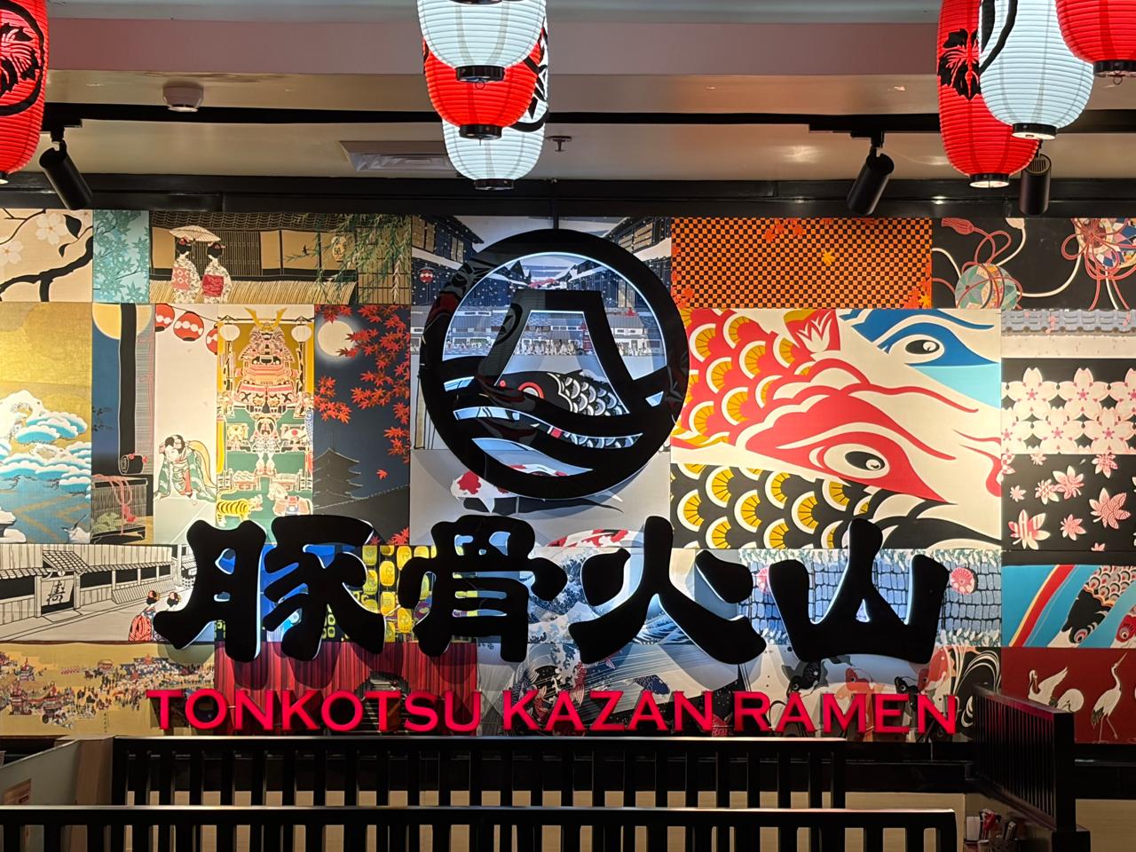 Tonkotsu Kazan Ramen dining room with Japanese artwork and the brand logo wall